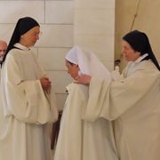 La supérieure est aidée pour enlever la chape blanche.