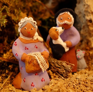 petit couple de santons devant la crèche